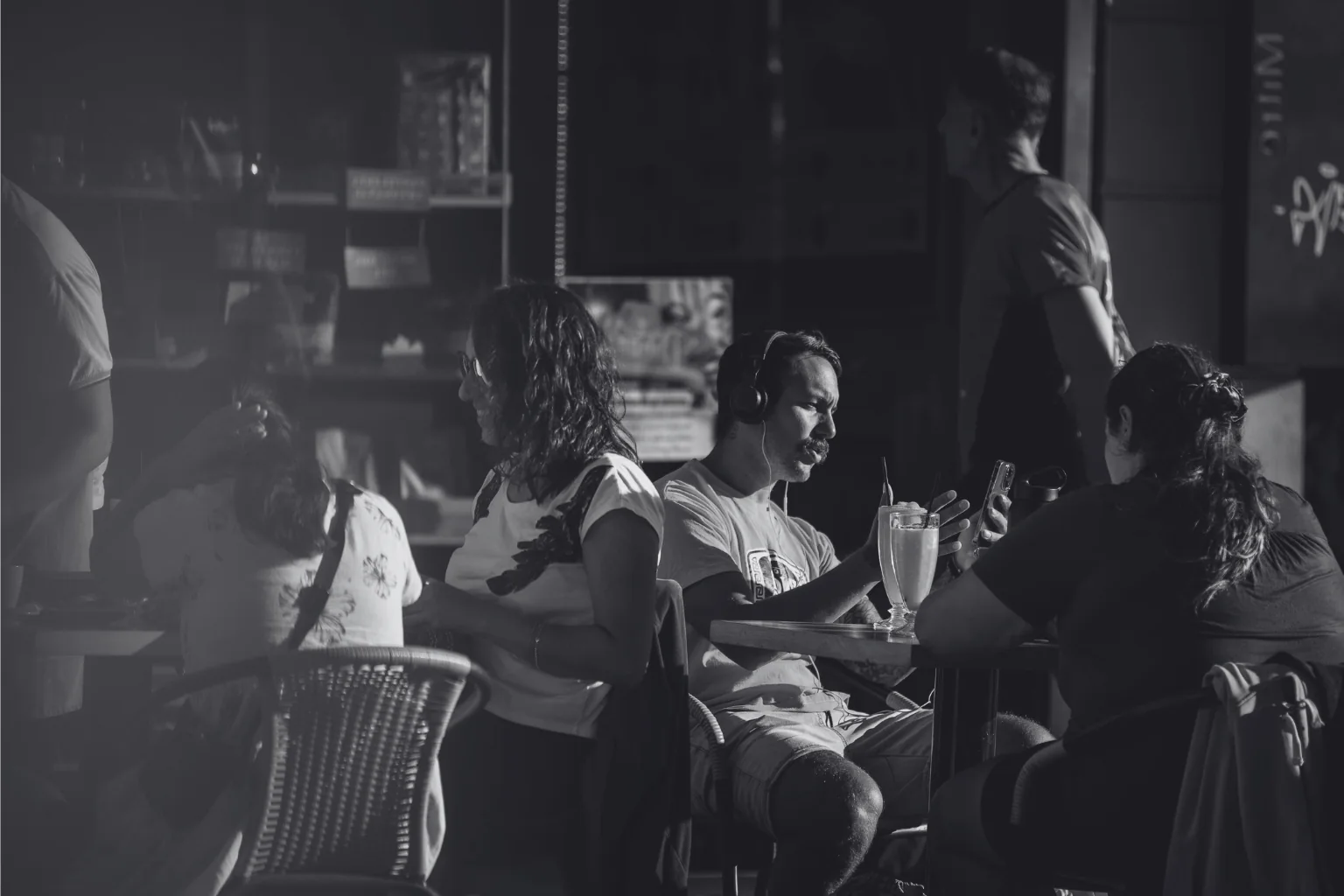 Gente conversando en las mesas de un bar al atardecer